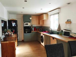 a kitchen with a refrigerator and a stove top oven at Maison plein sud 300m petite mer de Gâvres in Riantec