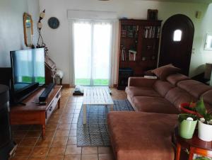 a living room with a couch and a flat screen tv at Maison plein sud 300m petite mer de Gâvres in Riantec