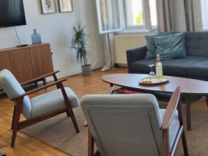 Una sala de estar con un sofá, una mesa y sillas. en Hej Bydgoszcz - Apartament XL na Starym Rynku, en Bydgoszcz