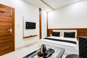 Una habitación de hotel con una cama y un televisor. en Super Hotel O Green, en Hisār