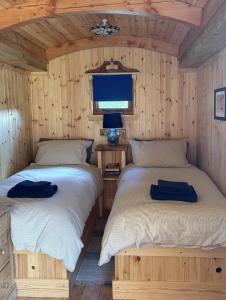 two beds in a room with wooden walls at Shepherd's Bothy, Bothan a Bhuachaille, Black Isle in Munlochy