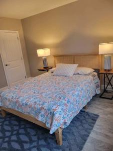 a bedroom with a bed and two lamps and two tables at Radiant Beach Block Condo Parking Patio in Brigantine