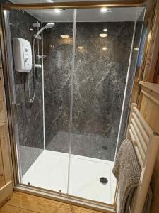 a shower with a glass door in a bathroom at Shepherd's Bothy, Bothan a Bhuachaille, Black Isle in Munlochy