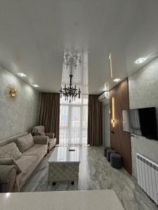 ItʼkhvisiDS & Sea Suites Batumi的客厅里有一张沙发和一台电视