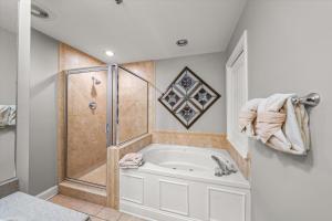 a bathroom with a shower and a tub at Midtown Bears Den in Gatlinburg +17 photos