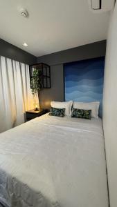 a bedroom with a large white bed with two pillows at Wanderlust Hostel in Maceió