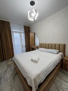 ItʼkhvisiDS & Sea Suites Batumi的卧室里有一张床，床上有一顶帽子