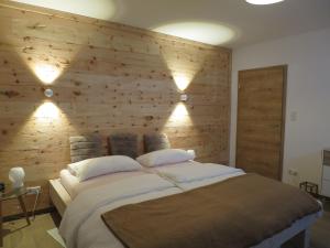 a bedroom with a large bed with a wooden wall at Morgenrot Panorama Apartment 1 - Terrasse in Gnotzheim