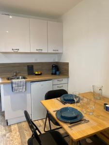 a kitchen with a wooden table with plates on it at Studio Erdeven proche de la mer et des randonnées in Erdeven