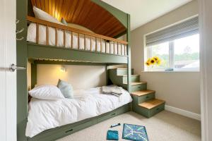 a green bunk bed in a room with a window at Wellingtonia Cottage in Chirbury