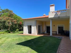 a house with a green lawn in front of it at A Casa dos Príncipes in Amoreira