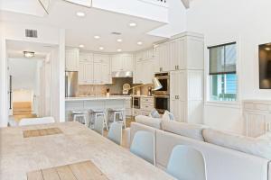 a kitchen with white cabinets and a table and chairs at Sunset Fairway Villa at Palmilla in Port Aransas