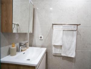 un bagno bianco con lavandino e specchio di Teranga Baobab a Dakar Altre 48 foto