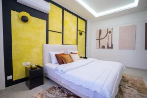una camera con un grande letto e una parete gialla di Teranga Baobab a Dakar