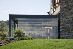 a glass extension of a building with a table and chairs at Borgo Capietaglio Wine Resort in Gromlongo