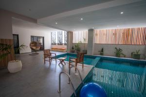 una piscina con due sedie e un tavolo e una piscina di Teranga Baobab a Dakar