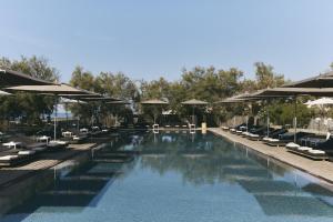 a swimming pool with lounge chairs and umbrellas at Hôtel Plage Palace & Spa in Palavas-les-Flots