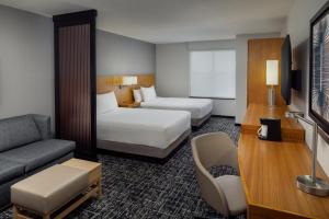a hotel room with two beds and a couch at Hyatt Place Chicago Midway Airport in Bedford Park +20 photos