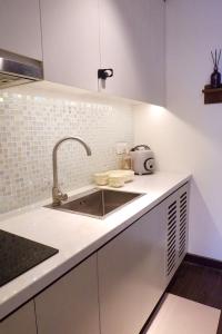 a kitchen with white cabinets and a sink at Best Western Premier Sapphire Hạ Long 2BR Homestay 55m2 in Ha Long