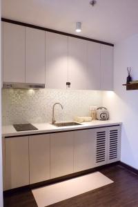 a kitchen with white cabinets and a sink at Best Western Premier Sapphire Hạ Long 2BR Homestay 55m2 in Ha Long