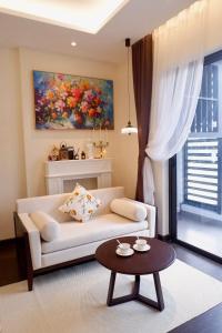 a living room with a white couch and a table at Best Western Premier Sapphire Hạ Long 2BR Homestay 55m2 in Ha Long