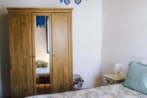 a bedroom with a wooden cabinet next to a bed at Jardim de Vénus in Vila de Frades +21 photos