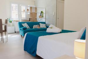een woonkamer met een blauwe bank en een blauw bed bij Mazara Moments in Mazara del Vallo