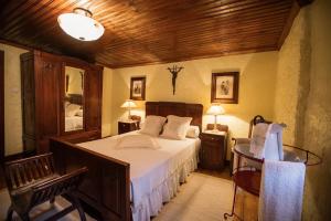 ein Schlafzimmer mit einem Bett und einer Holzdecke in der Unterkunft Quinta da Azenha by House and People in Valdosende