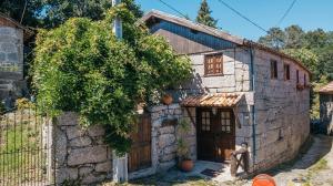 ein altes Steinhaus mit Holztür in der Unterkunft Quinta da Azenha by House and People in Valdosende