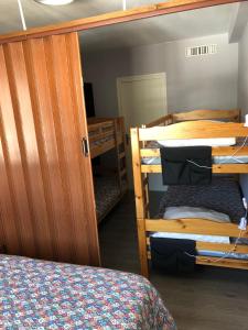 a room with three bunk beds and a bed at Appartement spacieux tout confort pied des pistes in Lélex