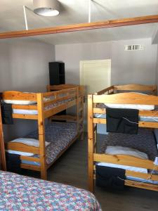 a room with three bunk beds and a television at Appartement spacieux tout confort pied des pistes in Lélex