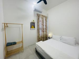 a white bedroom with a bed and a window at Aston Acacia Homestay in Bukit Mertajam +12 photos
