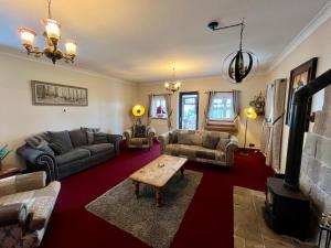 a living room with couches and a table at Starshinezzz - Large Farmhouse County Durham in Trimdon Grange