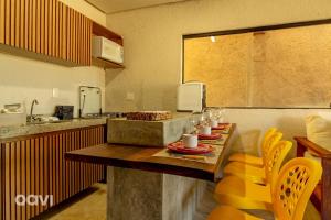 a kitchen with a table and yellow chairs in it at Casa com Área Privativa Lambari 07 by Qavi in São Miguel dos Milagres