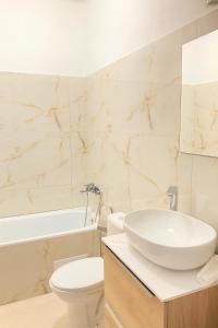 a bathroom with a sink and a toilet and a tub at Apartments parkFIVE in Lučenec +13 photos