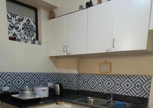 a kitchen with white cabinets and a sink at Davao Condo Chateau Soleil in Davao City