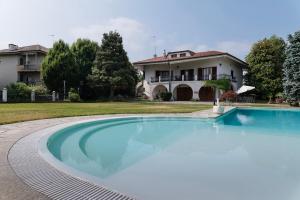 a large swimming pool in front of a house at Villa Massa in San Damiano dʼAsti