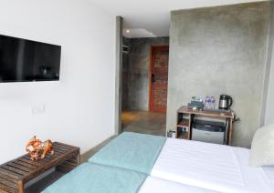a bedroom with a bed and a tv and a table at The Selene city hotel in Kandy
