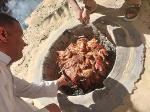 a man is cooking food in a brick oven at New star hotel in Siwa