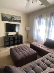 a living room with two ottomans and a television at Private Getaway with Balcony in Columbus