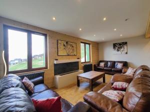 a living room with leather couches and a fireplace at Petit Mont Blanc Guest House in Peisey-Nancroix