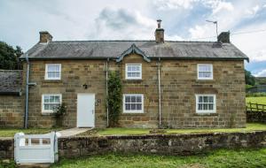Rose Cottage, Kepwick Village with Hot Tub - Rural Location في Kepwick: منزل من الطوب القديم مع باب أبيض
