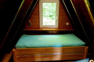 a small bed in a room with a window at Roter Fuchsbau am Eichwald in Gossersweiler-Stein