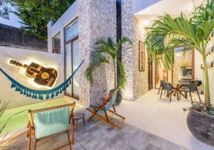 a patio with chairs and a guitar on the wall at Casa Bolero Santa Lucía with Parking by Cercana in Mérida