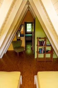 a attic room with two beds and a chair at Roter Fuchsbau am Eichwald in Gossersweiler-Stein