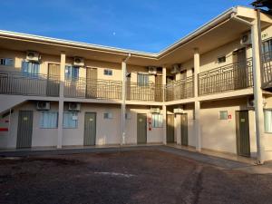 a large apartment building with balconies and a parking lot at Hotel Ideal in Ribas do Rio Pardo