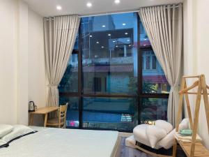 a bedroom with a bed and a large window at Nón House in Hanoi