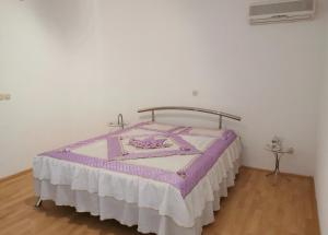a bedroom with a bed with a purple and white blanket at Villa Angelco in Novo Selo