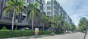 a street with palm trees in front of a building at My hip Condominium 2 Bedrooms 2 baths comfy room for family in Chiang Mai