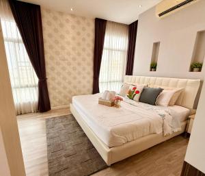 a bedroom with a large white bed with windows at My hip Condominium 2 Bedrooms 2 baths comfy room for family in Chiang Mai +36 photos